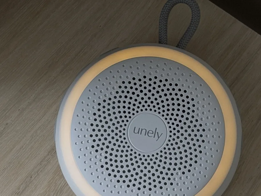 A portable speaker with a glowing ring on a wooden table — a product shoot for a UGC bundle