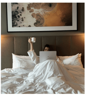 Gua sha facial massage in a bathrobe in front of a mirror